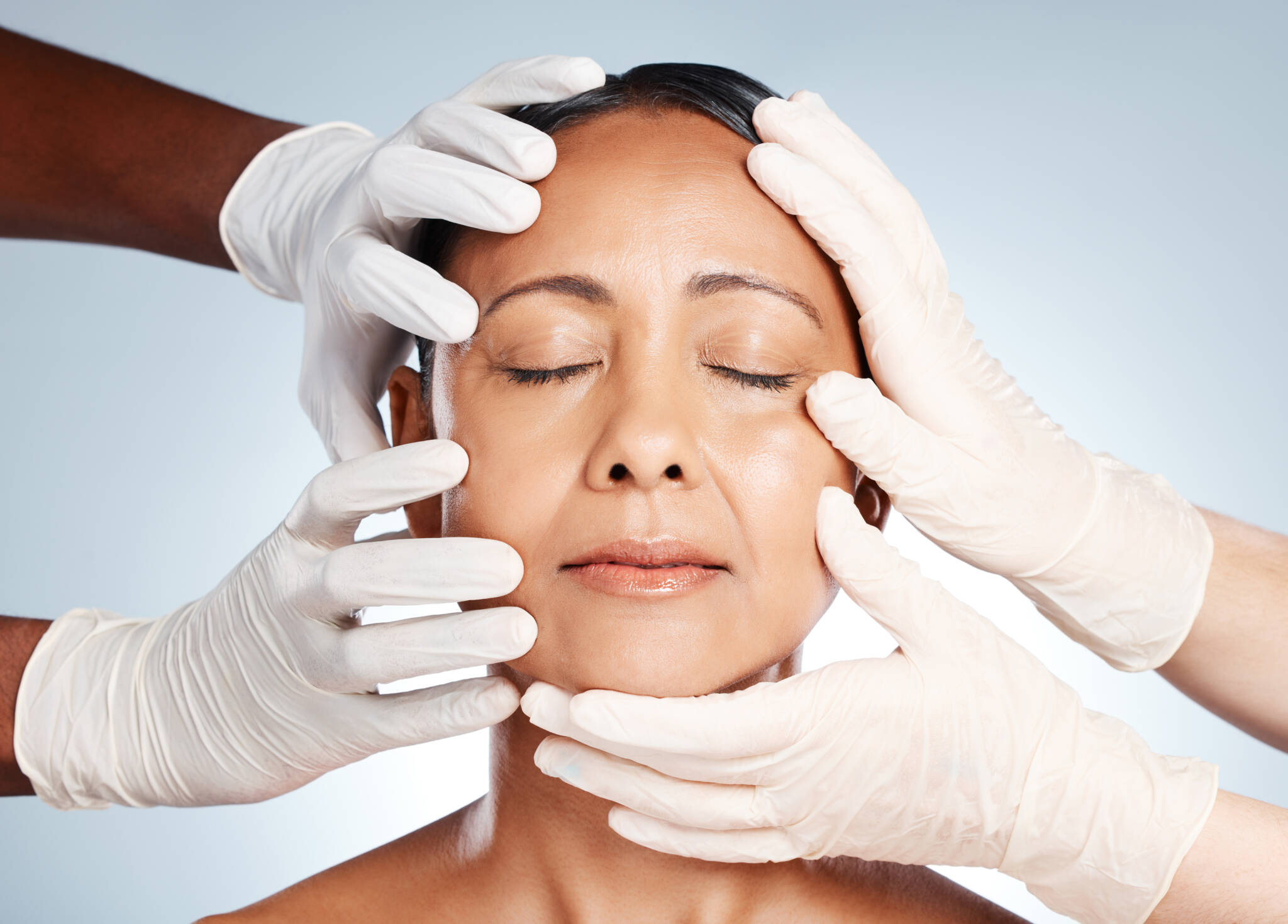 A woman's face is being evaluated to help decide between a facelift and a mini facelift. Facelifts and alternative procedures